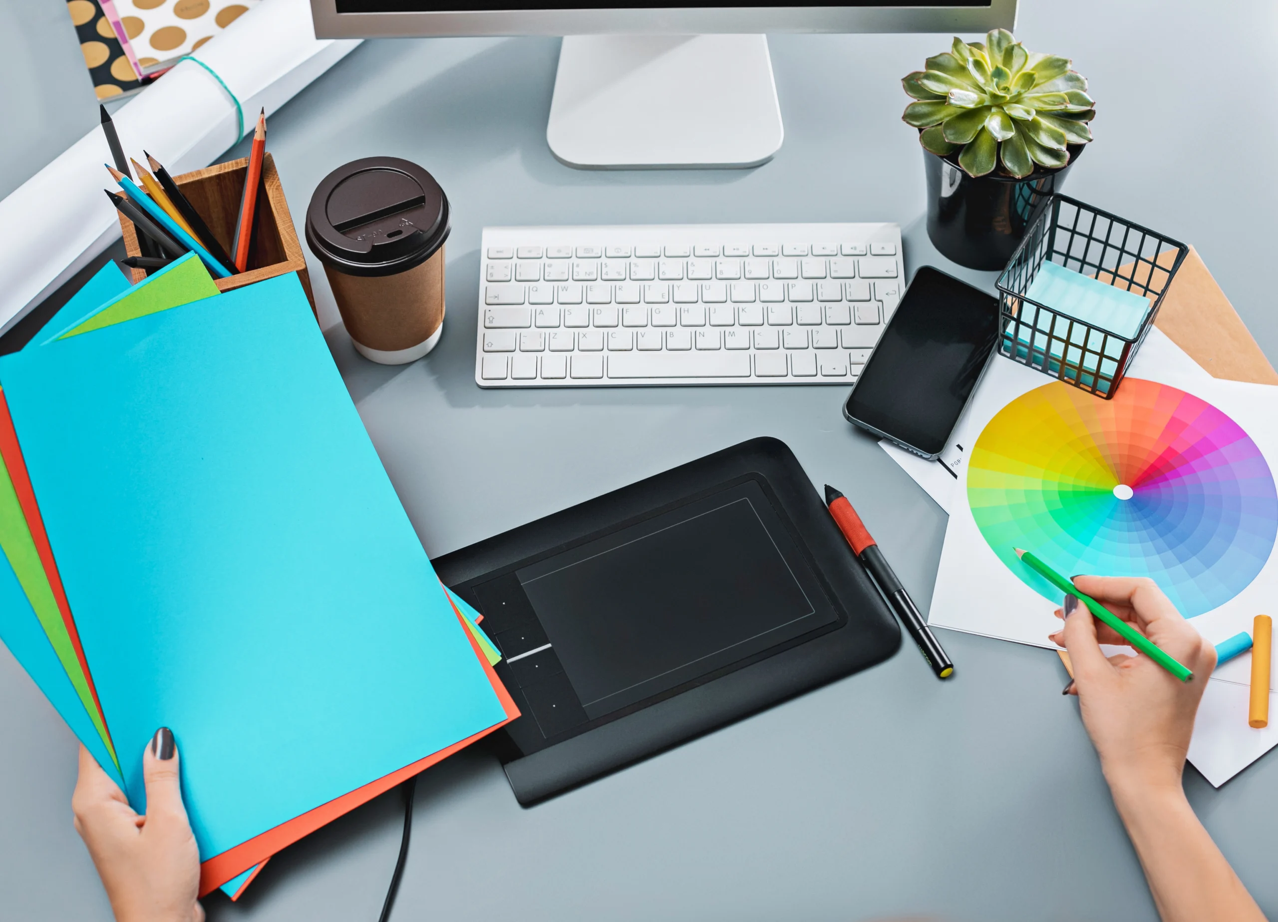 gray-desk-with-laptop-notepad-with-blank-sheet-pot-flower-stylus-tablet-retouching